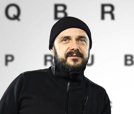 Dynamiczny portret Arkadiusza Jakubika, aktora i wokalisty, z elementami nawiązującymi do jego różnorodnej kariery artystycznej.