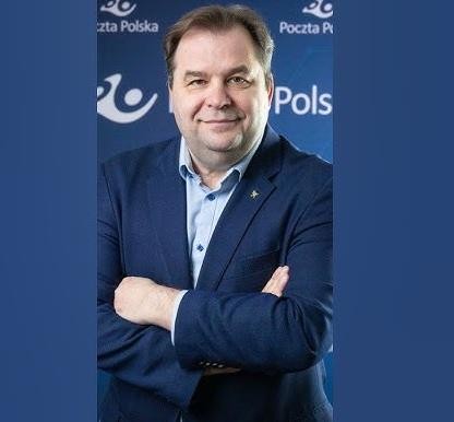 Dynamiczne ujęcie Sebastiana Mikosza w garniturze przed nowoczesnym samolotem, symbolizujące jego rolę w branży lotniczej.