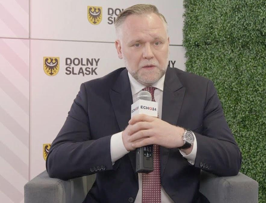 Symboliczna grafika przedstawiająca rozwój gospodarczy i bezpieczeństwo Polski, z elementami geometrycznymi i barwami narodowymi.