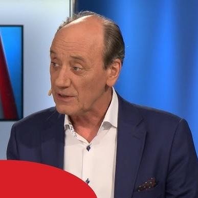 Dariusz Szpakowski w studiu nagraniowym, komentujący grę z serii FIFA, z mikrofonem i słuchawkami.