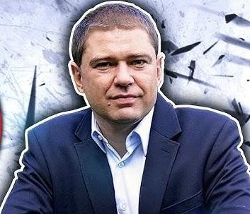 Piotr Szumlewicz przemawiający na wiecu lub debacie, z pasją i zaangażowaniem, w otoczeniu publiczności.