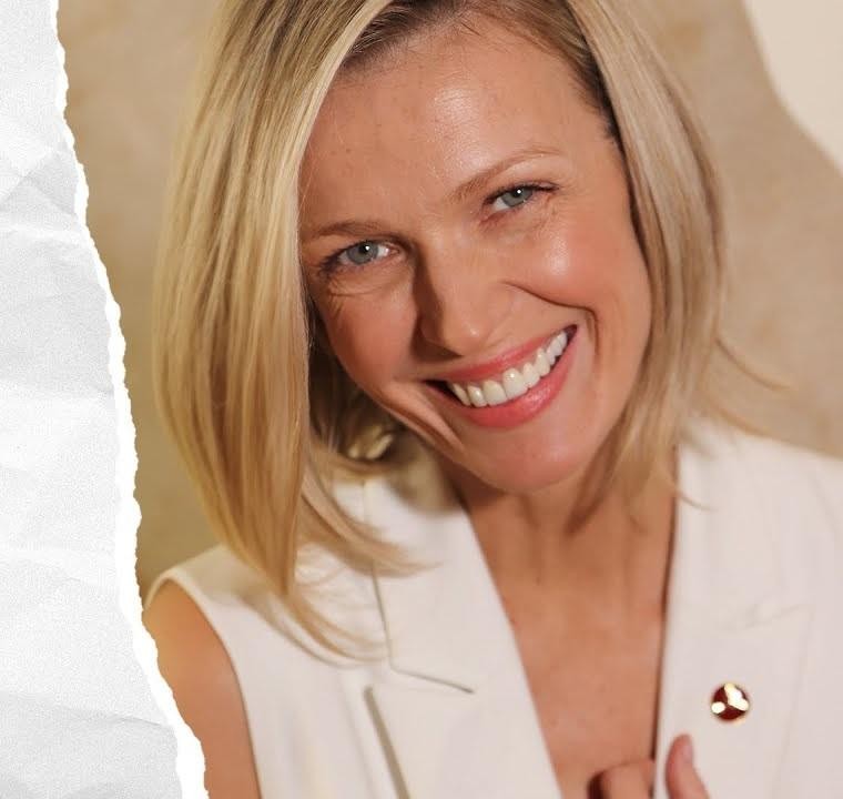 Magda Mołek przeglądająca Instagram na smartfonie, uśmiechnięta, w nowoczesnym wnętrzu.
