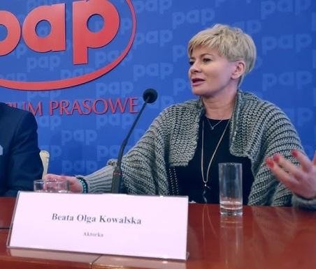 Beata Olga Kowalska na scenie teatralnej podczas występu, wyrażająca emocje, w dynamicznym oświetleniu.