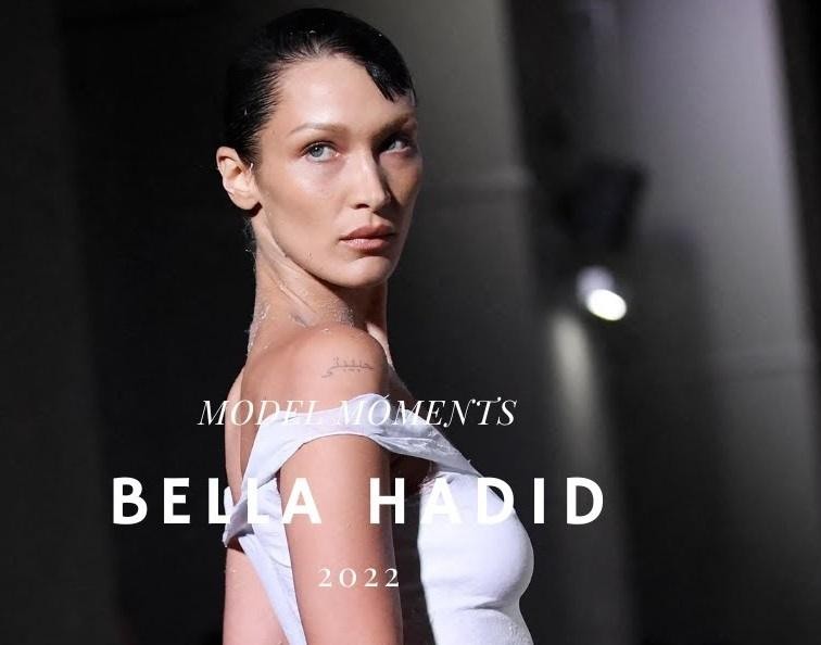Bella Hadid idąca po wybiegu podczas pokazu mody, prezentująca elegancką kreację, z pewnością siebie i profesjonalizmem.