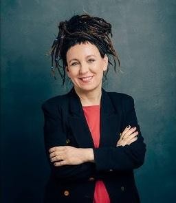 Olga Tokarczuk podczas Festiwalu Góry Literatury, uśmiechnięta, w otoczeniu natury, symbolizująca jej zaangażowanie w kulturę i ekologię.