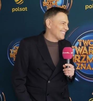 Krzysztof Ibisz w swobodnej interakcji z fanami lub współpracownikami na wydarzeniu medialnym.
